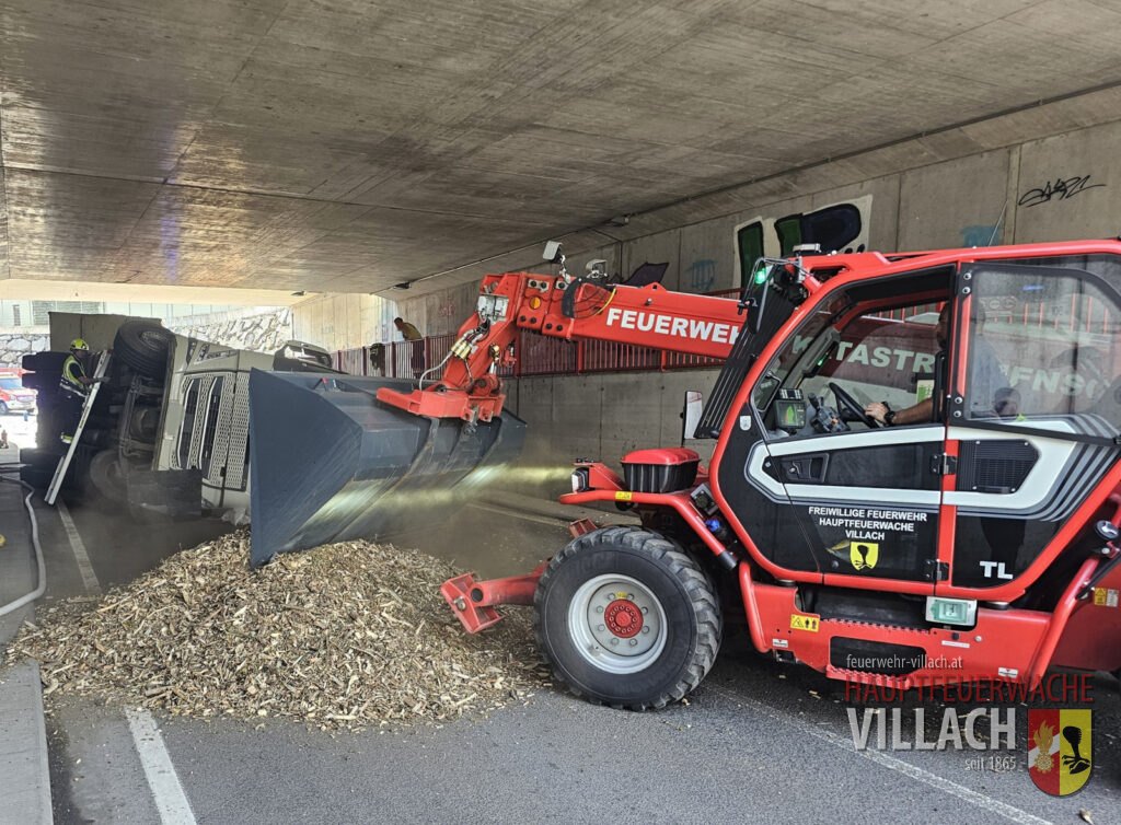 LKW in Eisenbahnunterführung umgestürzt – Suche unter Hackgutladung